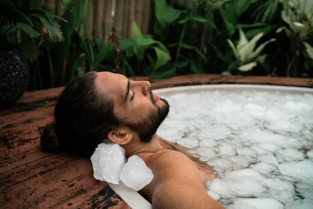 a man sitting in a tub filled with ice